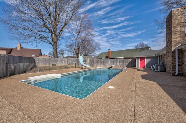 view of swimming pool with central air condition unit, a diving board, a patio area, and a water slide