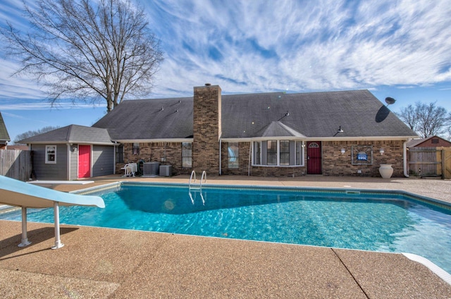 view of swimming pool with central AC unit, a patio, and a water slide