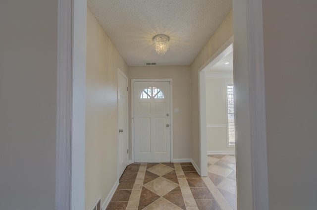 tiled entrance foyer featuring a healthy amount of sunlight and a textured ceiling