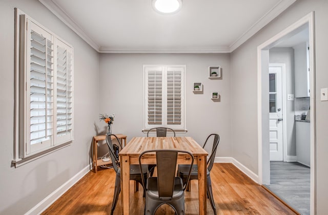 dining area featuring hardwood / wood-style flooring and ornamental molding