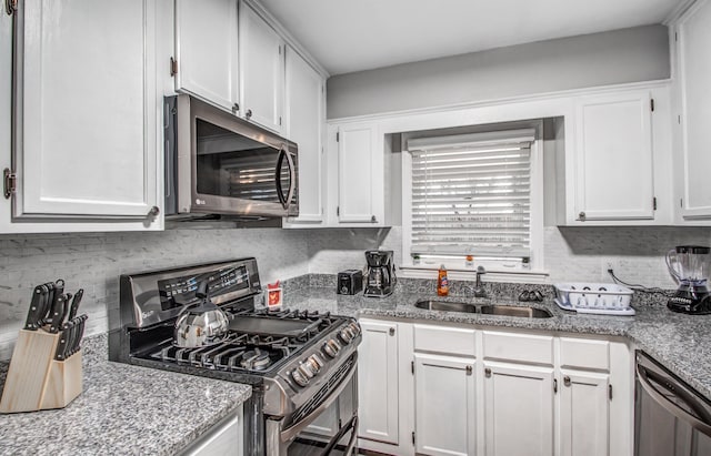 kitchen with white cabinets, light stone countertops, sink, and appliances with stainless steel finishes