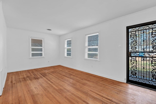 empty room featuring ornamental molding and light wood-type flooring