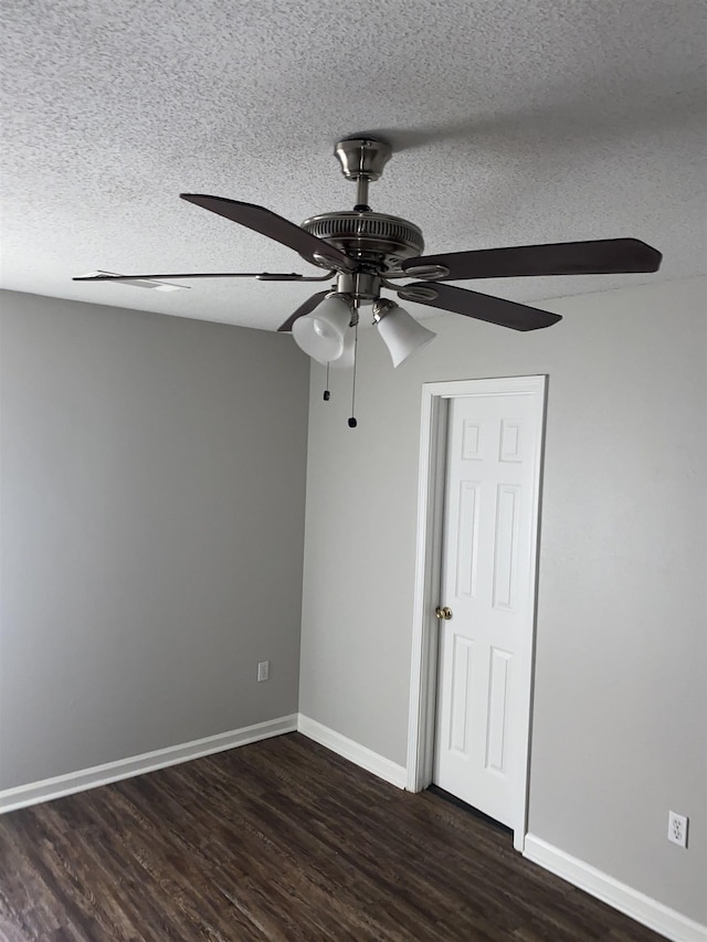 spare room featuring dark hardwood / wood-style flooring, a textured ceiling, and ceiling fan