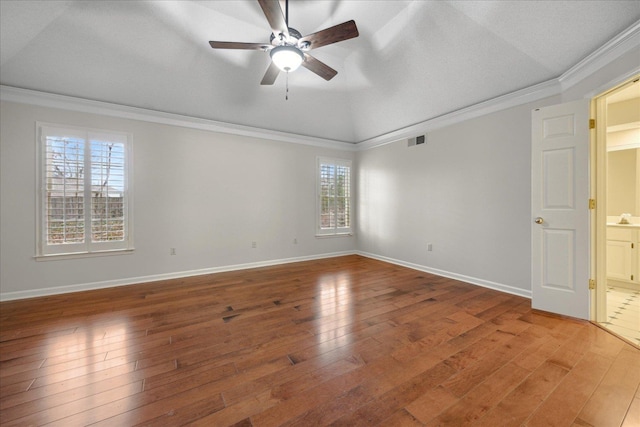 unfurnished room with hardwood / wood-style floors, crown molding, and a healthy amount of sunlight