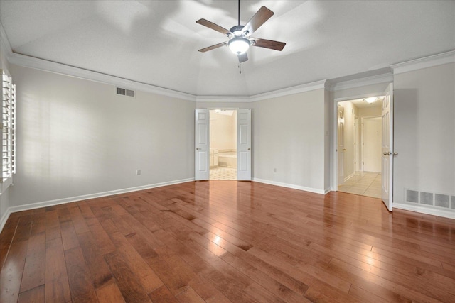 empty room with hardwood / wood-style flooring, ceiling fan, lofted ceiling, and crown molding