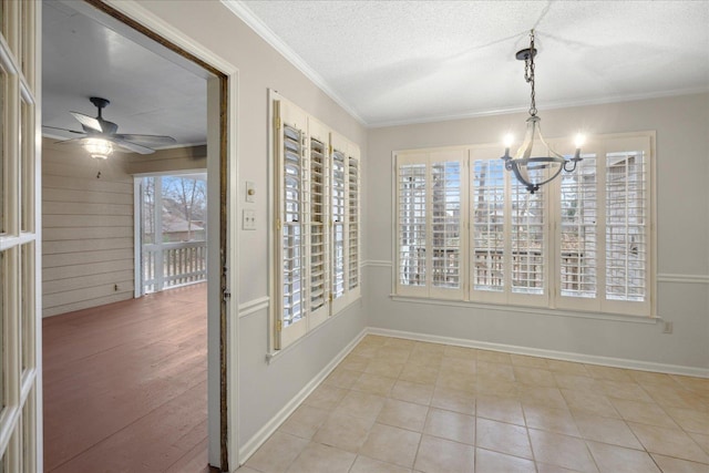 interior space with wood walls, ceiling fan with notable chandelier, ornamental molding, a textured ceiling, and light tile patterned floors