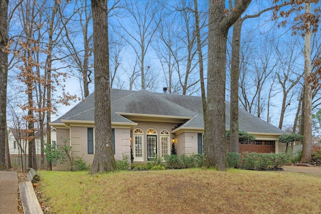 ranch-style house featuring a garage and a front yard