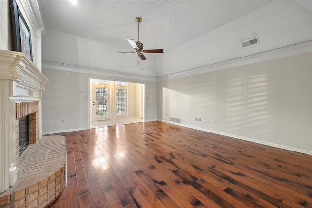 unfurnished living room with dark hardwood / wood-style flooring, ornamental molding, ceiling fan, a fireplace, and lofted ceiling