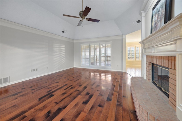 unfurnished living room with a brick fireplace, ornamental molding, ceiling fan, hardwood / wood-style flooring, and lofted ceiling