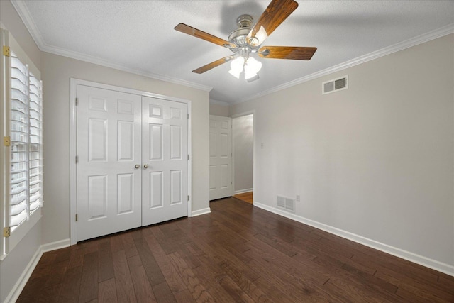 unfurnished bedroom featuring ceiling fan, dark hardwood / wood-style floors, ornamental molding, and a closet