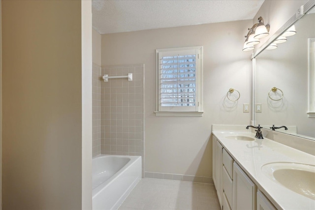 bathroom featuring tile patterned floors, vanity, tub / shower combination, and a textured ceiling