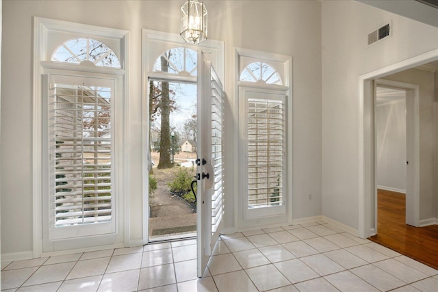 foyer entrance featuring light tile patterned floors and a chandelier