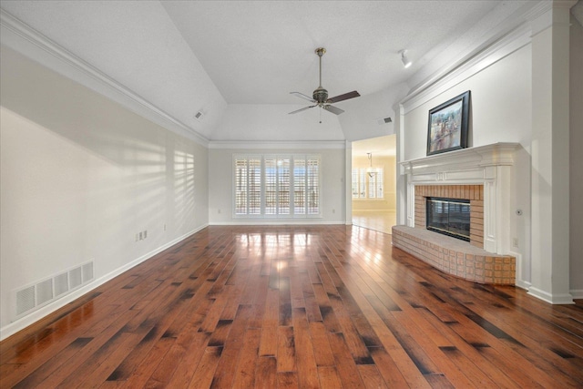 unfurnished living room featuring lofted ceiling, crown molding, dark hardwood / wood-style floors, ceiling fan, and a fireplace