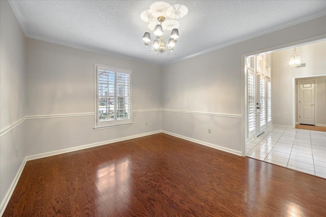 unfurnished room with hardwood / wood-style flooring, crown molding, a textured ceiling, and a chandelier