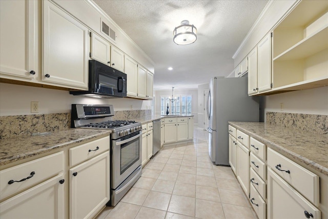 kitchen featuring stainless steel appliances, light stone counters, crown molding, a textured ceiling, and light tile patterned floors