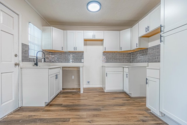 kitchen with dishwasher, white cabinetry, and sink