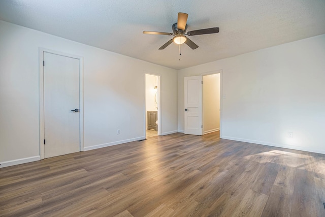 unfurnished bedroom featuring a textured ceiling, connected bathroom, ceiling fan, and dark hardwood / wood-style floors