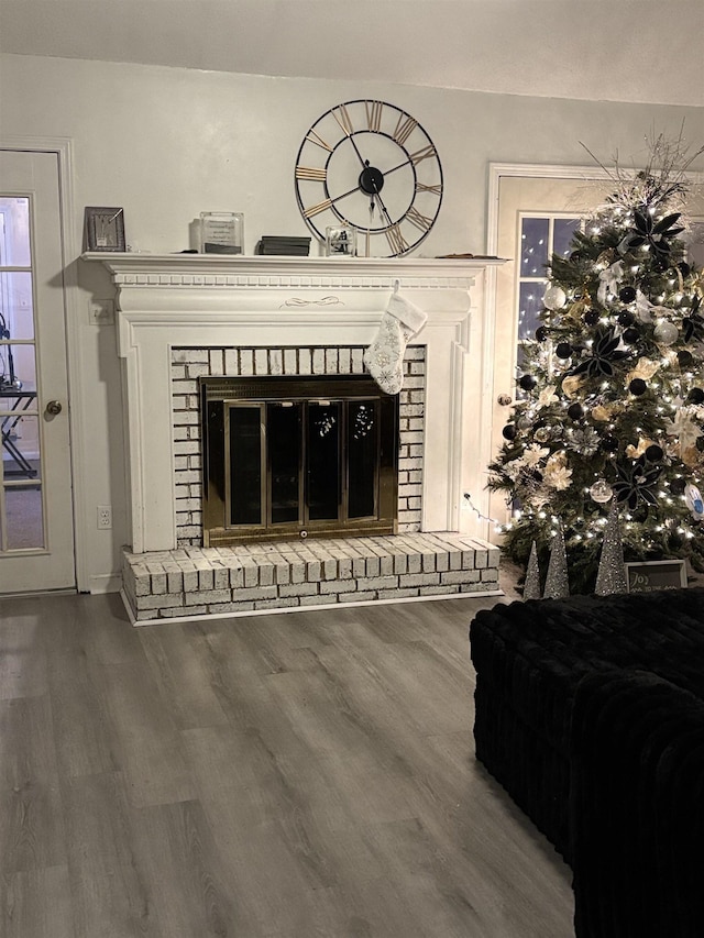 interior details with a brick fireplace and wood-type flooring