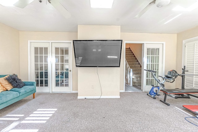 exercise area with ceiling fan, a skylight, and carpet flooring