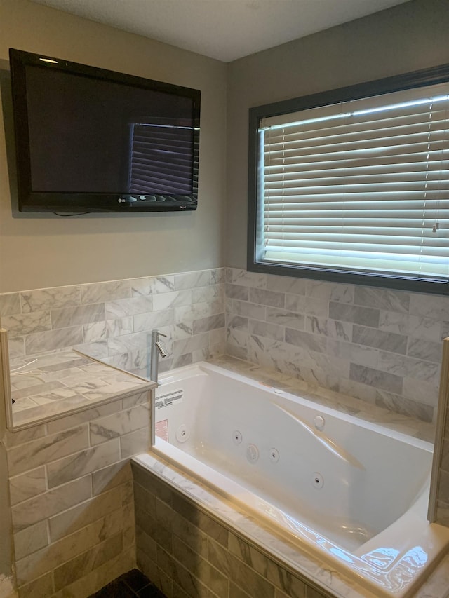 bathroom featuring tile patterned floors and a relaxing tiled tub