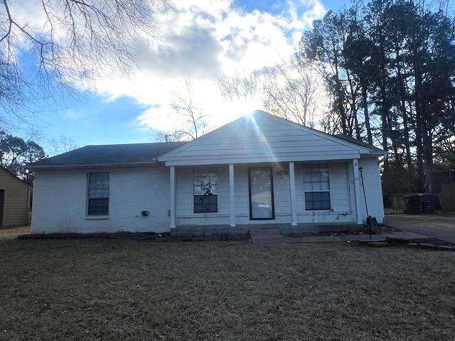 view of front of property featuring covered porch and a front yard