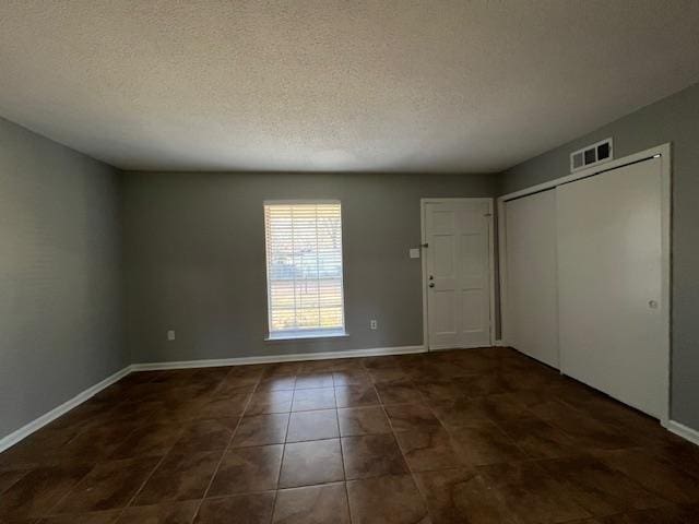 tiled foyer with a textured ceiling