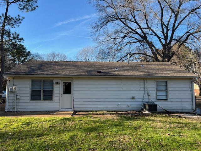 rear view of property with a yard and central AC unit