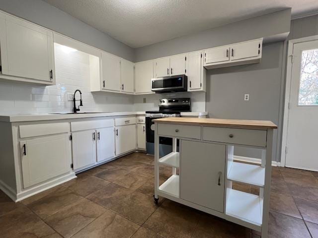 kitchen featuring white cabinets, a textured ceiling, electric range oven, and sink