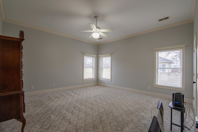 interior space with light carpet, multiple windows, ceiling fan, and ornamental molding