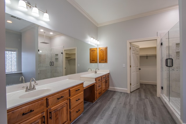 bathroom featuring hardwood / wood-style floors, vanity, a shower with door, and ornamental molding