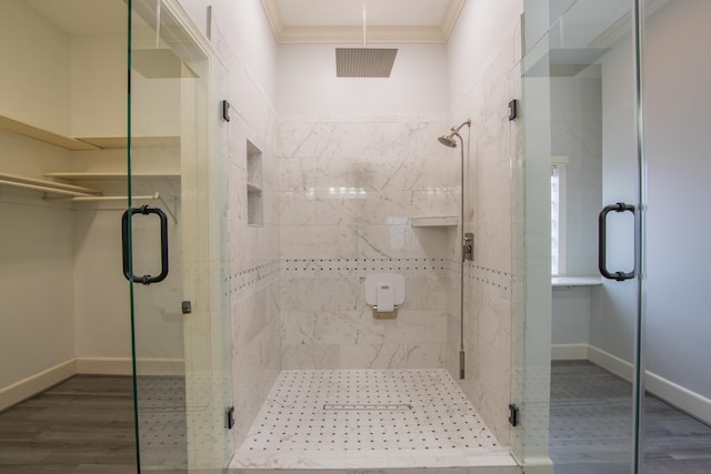 bathroom featuring an enclosed shower, wood-type flooring, and crown molding