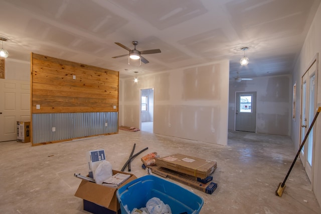 empty room with ceiling fan and wood walls