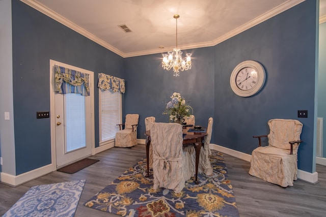 dining space with dark hardwood / wood-style flooring, crown molding, and a chandelier