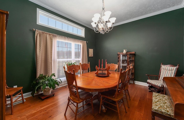 dining space featuring crown molding, hardwood / wood-style floors, and an inviting chandelier