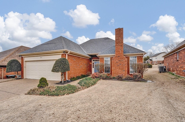 ranch-style house featuring a garage and cooling unit