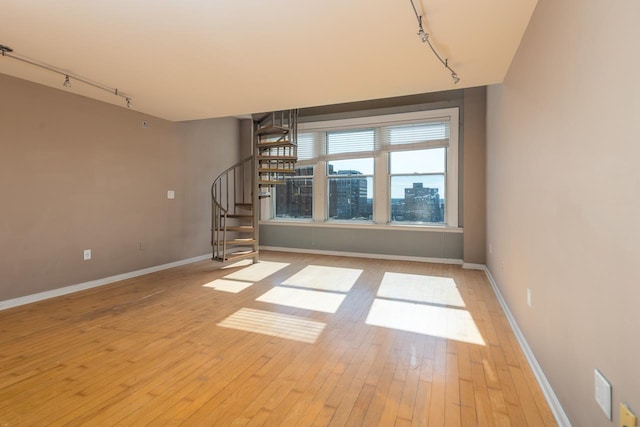 unfurnished living room featuring light hardwood / wood-style flooring and track lighting