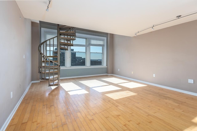 unfurnished room featuring track lighting and light hardwood / wood-style floors