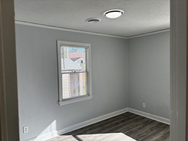 unfurnished room featuring dark wood-type flooring, a textured ceiling, and ornamental molding