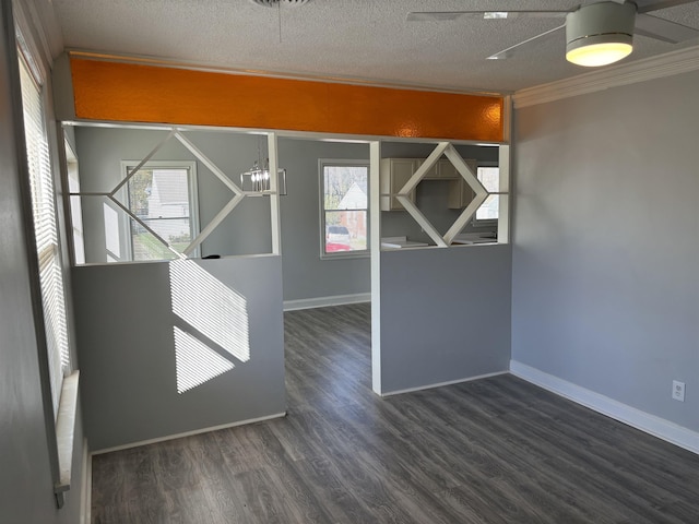 unfurnished room with a textured ceiling, dark hardwood / wood-style flooring, and ornamental molding