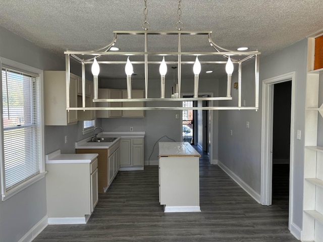 kitchen featuring a textured ceiling, a center island, dark hardwood / wood-style floors, and sink