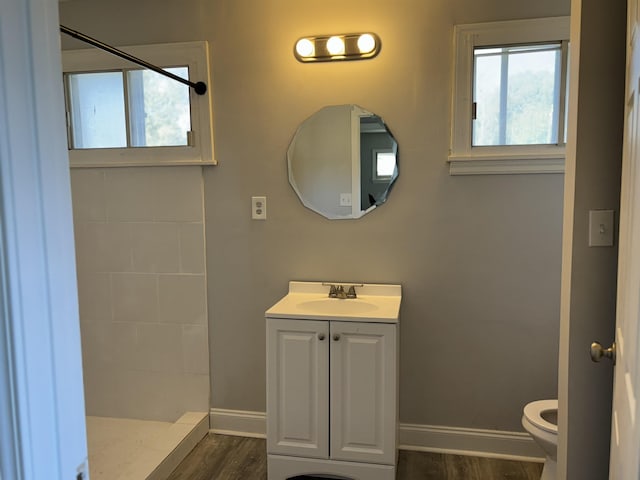 bathroom featuring vanity, toilet, wood-type flooring, and walk in shower