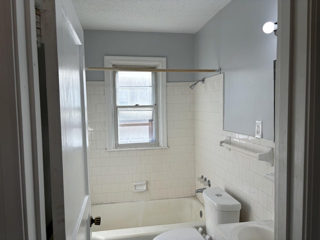 full bathroom featuring vanity, a textured ceiling, tiled shower / bath combo, tile walls, and toilet