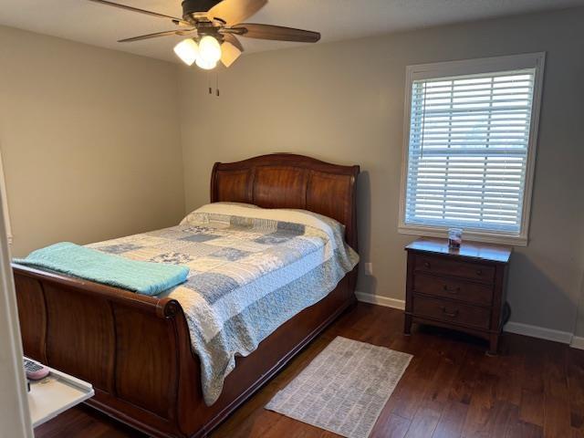 bedroom with ceiling fan and dark wood-type flooring