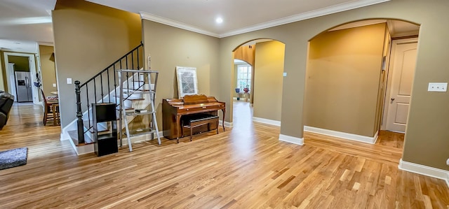 entryway with crown molding and light wood-type flooring