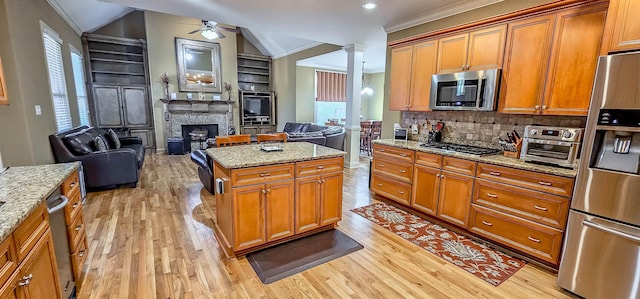 kitchen with light stone counters, lofted ceiling, and stainless steel appliances