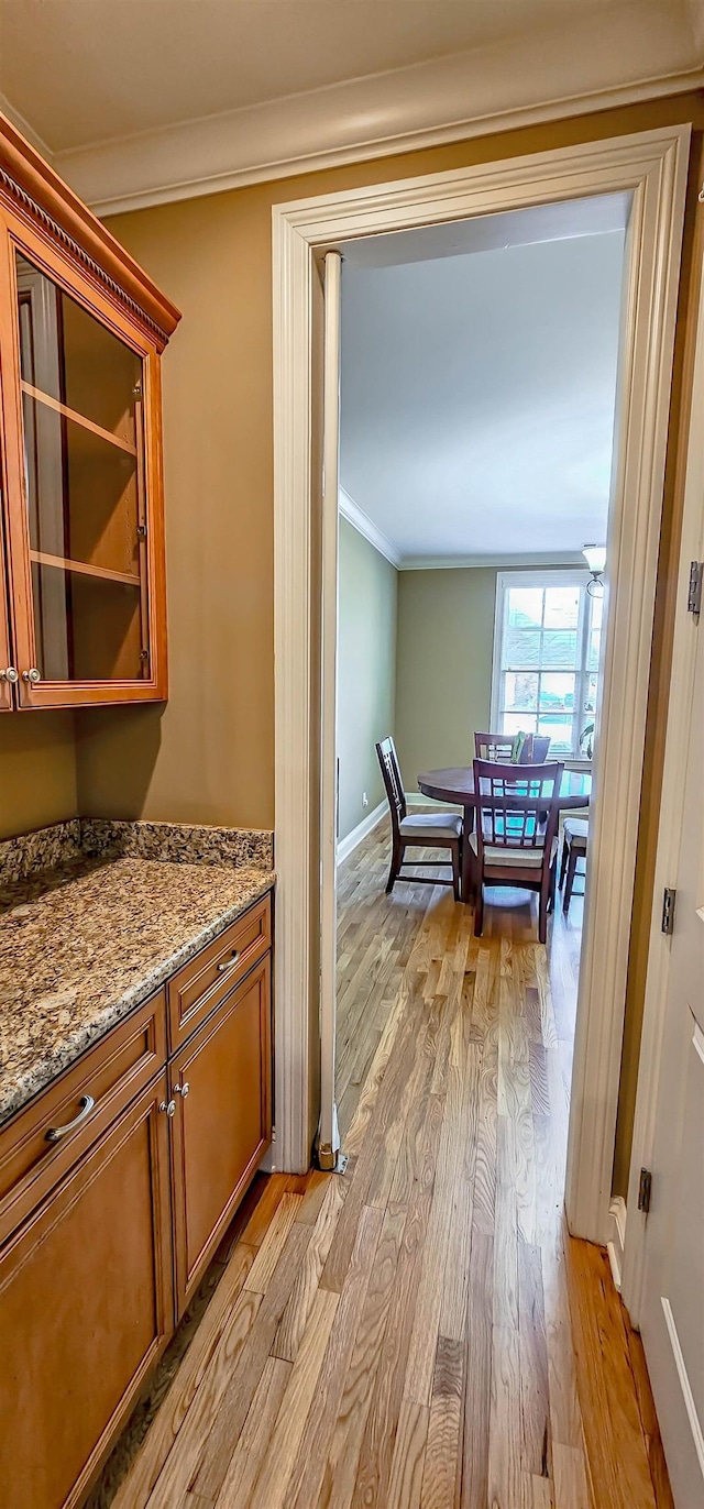 hall featuring light hardwood / wood-style floors and ornamental molding