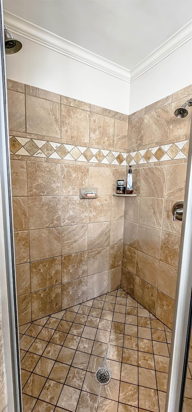 bathroom featuring a tile shower and ornamental molding