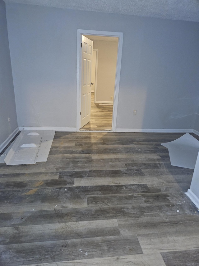 unfurnished room featuring dark hardwood / wood-style flooring and a textured ceiling