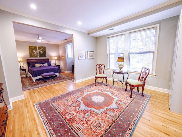 sitting room with ceiling fan, ornamental molding, and light wood-type flooring