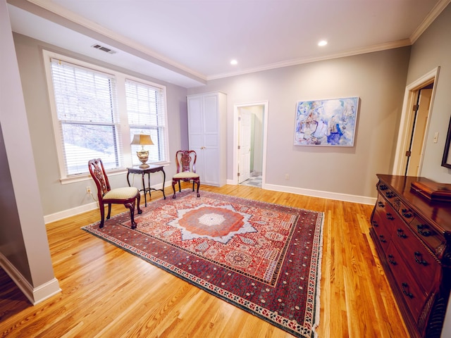 sitting room with light hardwood / wood-style floors and crown molding